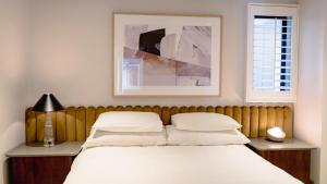 a bed with white sheets and pillows in a bedroom at The Max Hotel Sandton in Johannesburg +46 photos