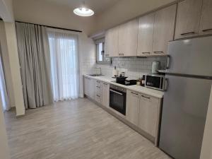 a kitchen with a stainless steel refrigerator and cabinets at Elounda Alley in Elounda