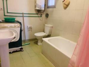 a bathroom with a tub and a toilet and a sink at 新开罗富人区rehab华人名宿 in Cairo