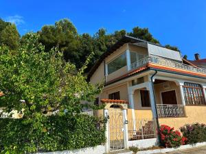 a yellow house with a gate and bushes at Villa Lollo in Camporosso