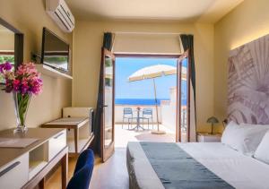 a hotel room with a bed and a view of the ocean at Hotel Baia Imperiale in Campo nell'Elba