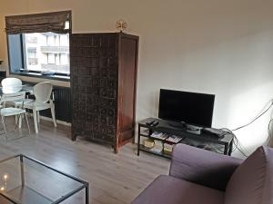 Una sala de estar con un sofá, un televisor y una mesa. en Appartment Bella - 2 minutes from the beach, en Noordwijk aan Zee 39 fotos más