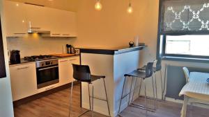 una cocina con encimera y sillas. en Appartment Bella - 2 minutes from the beach, en Noordwijk aan Zee