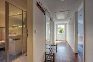 ein Flur mit einem Badezimmer mit Waschbecken und Spiegel in der Unterkunft Landhaus am Ufer - Wohnung 4 in Heiligenhafen