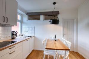 ハイリゲンハーフェンにあるLandhaus am Ufer - Wohnung 3のキッチン(木製テーブル、白い椅子付) +23枚の写真
