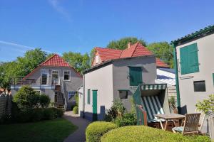 ハイリゲンハーフェンにあるLandhaus am Ufer - Wohnung 2の家2軒、テーブルと椅子が備わる庭