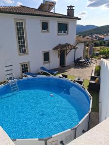 a villa with a swimming pool and a house at A Nossa Casa in Castelejo