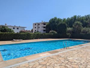 a swimming pool with blue water in a yard at Le Pastis - Direct aan het strand en het centrum - Top locatie! in Cavalaire-sur-Mer