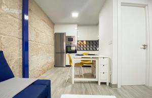 a small kitchen with a table and yellow chairs at SOCAIRO in Cangas de Morrazo