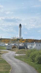 a lighthouse on a hill with a road leading to it at Lighthouse View in Lossiemouth