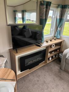 a living room with a flat screen tv and a couch at Lighthouse View in Lossiemouth