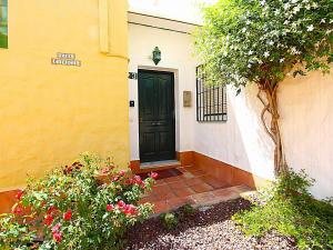 czarne drzwi na żółtym budynku z kwiatami w obiekcie Casablanca Villas w mieście Nerja