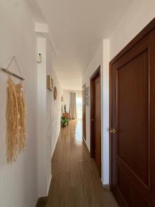 a hallway with a door and a wooden floor at Mar y Sol in Empuriabrava