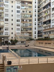 een zwembad voor hoge gebouwen bij Sweet Home Agadir Appartement moderne avec piscine et commerces à pied in Agadir