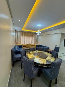 een kamer met een tafel, stoelen en een bank bij Sweet Home Agadir Appartement moderne avec piscine et commerces à pied in Agadir
