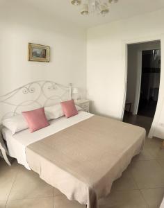a bedroom with a large bed with two pink pillows at Alba b&b in Polignano a Mare