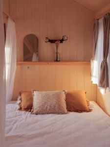 a bed with two pillows on it in a room at Hébergement insolite en Dordogne in Saint-Amand-de-Coly +129 photos