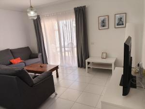 a living room with a couch and a tv at Bungalow Golf del Sur in San Miguel de Abona