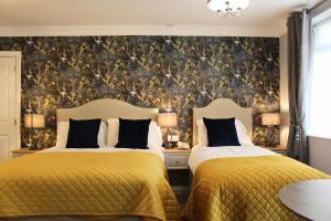 two beds in a bedroom with a wallpaper at Ardboyne Hotel in Navan
