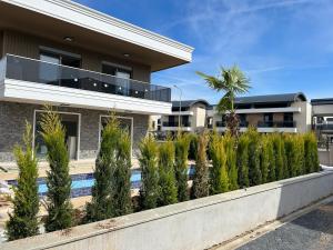 a house with a row of trees in front of it at Nirvana Belek Villas Manolya in Belek