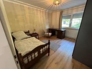 Un dormitorio con una cama, un escritorio y un piano. en WALDnah Rückzugsort in Haiterbach, en Haiterbach