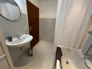 Un baño con lavabo, bañera y espejo. en WALDnah Rückzugsort in Haiterbach, en Haiterbach