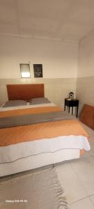 a bedroom with two beds and a table at Kitnet 17a in São Luís +4 photos