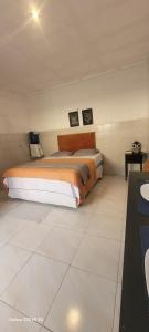 a bedroom with two beds and a tiled floor at Kitnet 17a in São Luís