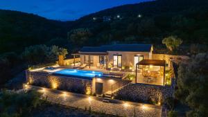a villa with a swimming pool at night at Lefkira Seafront Villa in Évyiros
