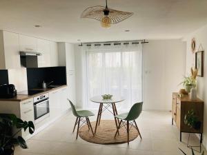 a kitchen with a table and chairs in a room at Logement cosy en centre ville in Talmont