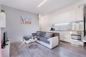 a living room with a couch and a kitchen at Cozy Guesthouse in Koskinou