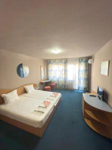 a bedroom with a bed and a desk and a television at Лозенец Резорт in Lozenets +22 photos