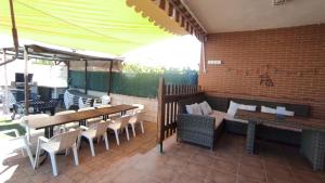 a patio with tables and chairs on a brick wall at La Casa de Taramona, cerca de Puy Du Fou in Barcience