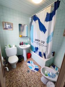 un bagno con lavandino, water e tenda da doccia di Villa T de Pescadores a Dumbría Altre 13 foto