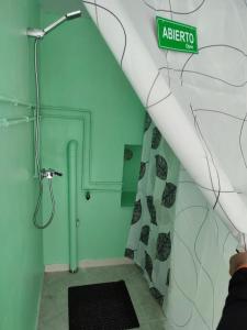 un bagno con doccia e un cartello sul muro di Villa T de Pescadores a Dumbría