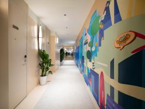 a hallway with a mural on the wall at Layflat Hotel in Shenzhen
