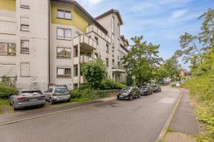 a row of cars parked on a street next to buildings at Rob's Flat - Moderne 3-Zimmer-Ferienwohnung mit Terrasse, 6 Schlafplätzen, 2 Min S-Bahn, Weil der Stadt bei Stuttgart in Weil der Stadt