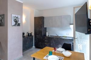 a kitchen with a wooden table and a dining room at Casa Quadrifoglio - Spalavera in Intra +16 photos