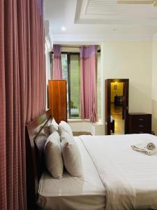 a bedroom with a bed with white pillows at Executive Galaxy Guest House Islamabad in Islamabad