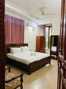 a bedroom with a bed and a chair in it at Executive Galaxy Guest House Islamabad in Islamabad