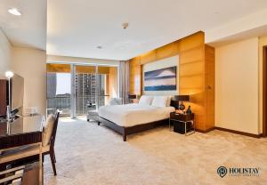 ein Schlafzimmer mit einem Bett, einem Schreibtisch und einem Fernseher in der Unterkunft Kempinski Central Avenue Residence - Direct Access Dubai Mall in Dubai + 23 Fotos