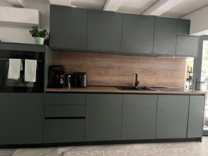 a kitchen with gray cabinets and a sink at Szigligeti Strand Apartman in Szigliget
