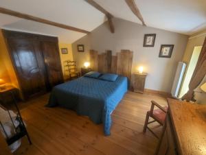 una camera da letto con un letto e un pavimento in legno di La Maison de Marie - Chambres d'Hôtes au Lac du Der a Droyes