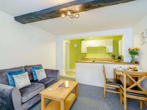 Una sala de estar con un sofá y una mesa y una cocina. en 2 Bed in Cockermouth 85514, en Cockermouth