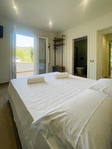 a large white bed with two pillows on top of it at The Villa - Lascari Cefalu' in Lascari