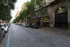 una calle adoquinada con coches estacionados al lado de un edificio en Vaticano 38 Suites, en Roma