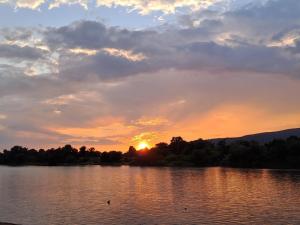 a sunset on a lake with the sun setting at Zara spa free in Veliko Gradište