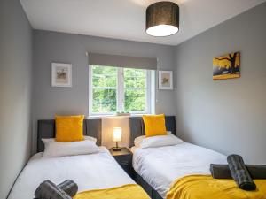 two beds in a room with yellow pillows at House Sleeps6-Garden-PetsOk-Parking-Long stay disc in Nottingham