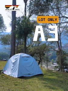 a blue tent sitting in the grass next to a tree at The Hunting Rat Campsite in Ban Tai