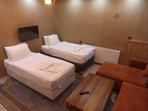 a hotel room with two beds and a table at Ruşen otel in Bostaniçi